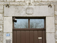 Dessus de la porte d’entrée du presbytère. Sur son linteau en pierre de taille, on peut lire le millésime 1828 gravé en saillie.