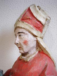 Saint Eloi de Noyon - Chêne, restes de polychromie, 44 cm - Ecole mosane (sculpteur régional), vers 1520-30. Né dans le Limousin, mort à Noyon en 660. Orfèvre, il fut le maître des monnaies de Clotaire II, puis trésorier de Dagobert 1er. Il fonda le monastère de Solignac (632) qu’il confia à saint Remacle. Il étendit le Christianisme dans le Nord de la France. Il est le patron des orfèvres et des forgerons. - Ici il est représenté mitré. Vu de profil, il dégage une forte impression de bienveillance. Le sculpteur, naïf dans l’âme, a su donner à ce visage un souffle apaisant mais fort de ses certitudes.