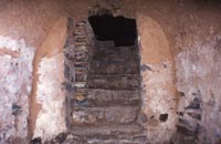 Escalier d’accès et ses six marches. A remarquer : l’arc en plein cintre maladroit existant à l’entrée de la « cave ».